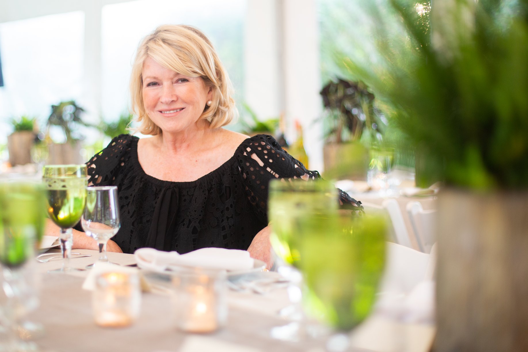 Martha Stewart seated and smiling at an event produced by Golden Circle's principal in the Hamptons
